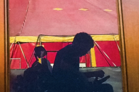 a man in motorized wheelchair sits in front of a circus tent
